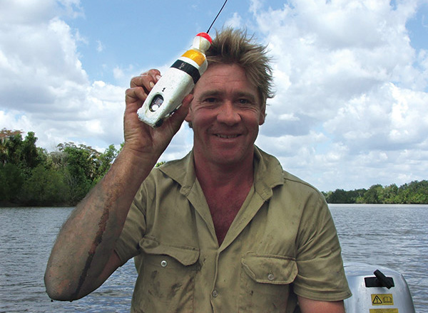 Steve Irwin holding a device.